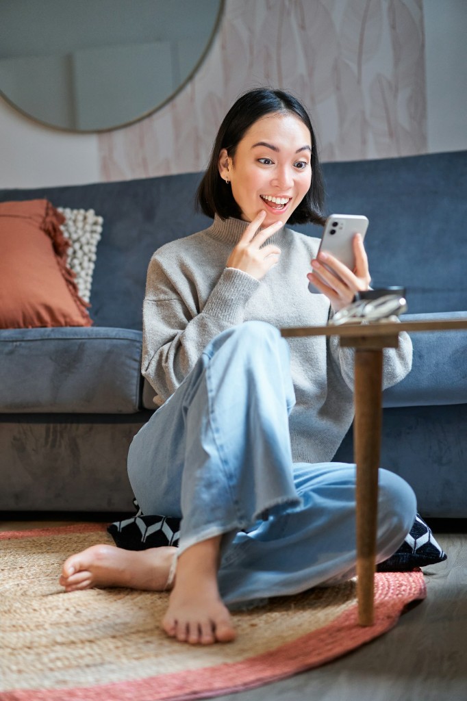 Person relaxed at home, pleased while checking portfolio insights on a phone.